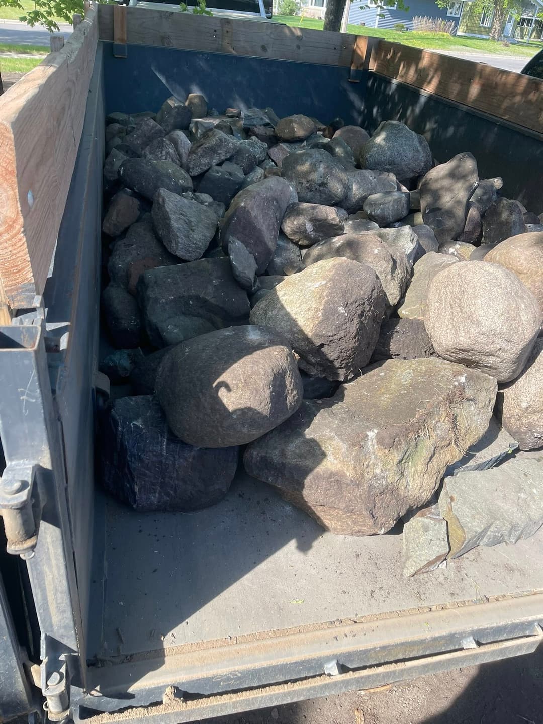 Dump truck filled with large rocks, ready for landscaping or construction projects.