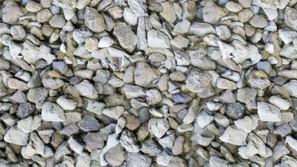 Close-up of diverse, textured gravel stones in varying colors and sizes on a flat surface.